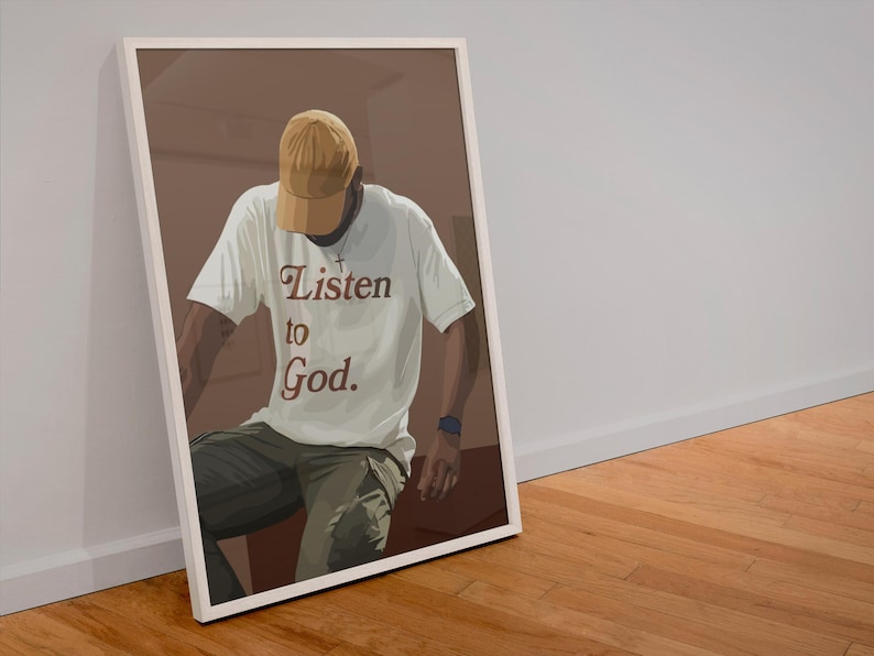 May include: A person wearing a white t-shirt with the text "Listen to God." in brown lettering. The person is wearing a brown and yellow baseball cap and khaki pants.