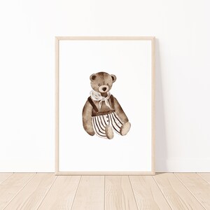 May include: A brown teddy bear wearing a white and black striped outfit with a brown belt and a white scarf. The bear is sitting on a white background.