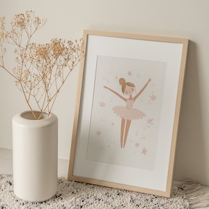May include: A framed illustration of a ballerina in a pink tutu with a light pink background and small pink flowers. The frame is made of light wood.