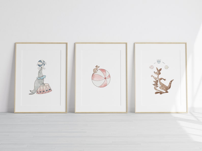 Puede incluir: Tres ilustraciones de acuarela enmarcadas de animales de circo. La primera muestra una foca equilibrando una pelota en su nariz. La segunda muestra un rat&oacute;n sentado encima de una pelota grande. La tercera muestra un canguro haciendo malabares con tres pelotas.