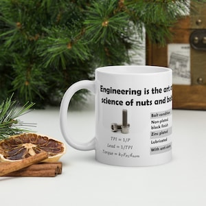 Può includere: Una tazza in ceramica bianca con una grafica nera che dice "L'ingegneria è l'arte e la scienza dei dadi e dei bulloni". La grafica include anche uno schema di un bullone con il testo "TPI = 1/P, Lead = 1/TPI, Torque = k+FPLdnom" e un elenco di condizioni del bullone: "Finitura nera non placcata, Placcato zinco, Lubrificato, Con anti-grippage."