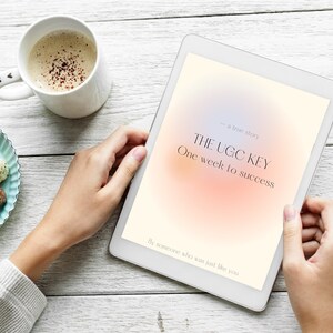 以下が含まれることがあります： オレンジとピンクのぼやけた背景の白いタブレットコンピュータ。画面のテキストは「THE UGC KEY - a true story. One week to success. By someone who was just like you.」です。