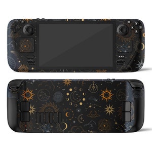 Può includere: Una console per videogiochi portatile nera con un design celeste. La console ha uno schermo nero e dettagli dorati. Il design presenta stelle, lune e soli.