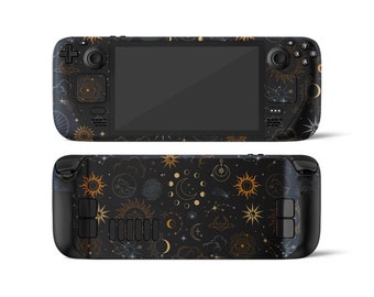 May include: A black handheld gaming console with a celestial design. The console has a black screen and gold accents. The design features stars, moons, and suns.