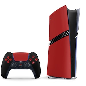 Puede incluir: Una consola de videojuegos roja y negra con un mando negro a juego. La consola tiene un diseño elegante y moderno con un panel frontal rojo y un panel lateral negro. El mando tiene un cuerpo negro con botones rojos y una almohadilla táctil roja.