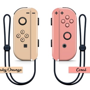 K&ouml;nnte beinhalten: Zwei Nintendo Switch Joy-Con-Controller, einer in Baby-Orange und einer in Koralle, mit schwarzen Handgelenksb&auml;ndern. Die Controller haben das Standard-Tastenlayout und werden vor einem wei&szlig;en Hintergrund gezeigt.