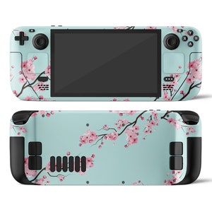 May include: A light blue handheld gaming console with a floral design featuring pink cherry blossoms. The console has black buttons and a black screen.