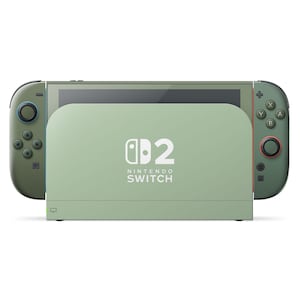 Puede incluir: Una consola Nintendo Switch verde salvia con mandos Joy-Con a juego. La consola está acoplada en una estación de carga verde salvia. El logotipo de Nintendo Switch y el número "2" están impresos en la estación de carga.