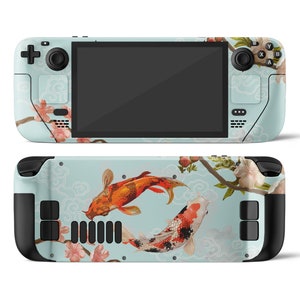 Könnte beinhalten: Eine blaue und weiße Handheld-Spielkonsole mit einem floralen und Koi-Fisch-Design. Die Konsole hat zwei schwarze Knöpfe unten und zwei schwarze Knöpfe oben.