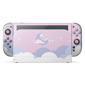 以下が含まれることがあります： パステルカラーの空のデザインが施された、カスタムスキン付きのNintendo Switchコンソール。ピンク、ブルー、ホワイトの色合いで三日月、雲、星が描かれています。Joy-Conコントローラーも同様のデザインです。