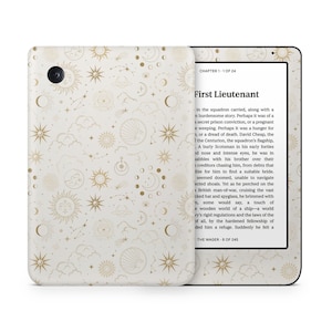 May include: An e-reader with a celestial design. The cover has a pattern of gold suns, moons, stars, and clouds on a cream background. The screen displays text from a book. The e-reader is open, showing the screen.