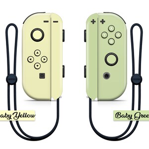 K&ouml;nnte beinhalten: Zwei Nintendo Switch Joy-Con-Controller, einer in Babygelb und einer in Babygr&uuml;n, mit schwarzen B&auml;ndern befestigt.