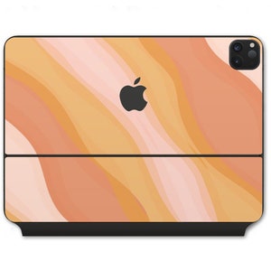 Könnte beinhalten: Ein schwarzes Laptop-Case mit einem abstrakten Design in Rosa, Orange und Gelb mit wellenförmigen Linien. Das Case hat ein schwarzes Apple-Logo und ein schwarzes Kameraobjektiv.