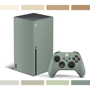 Pode incluir: Um console Xbox Series X verde-sálvia com um controlador verde-sálvia correspondente. O console tem uma ventilação preta na frente e um logotipo Xbox preto no topo.