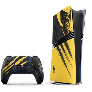 May include: A video game console and a wireless controller featuring a yellow and black color scheme. The console displays a graphic of a character with a mask and claw marks, while the controller has matching yellow brush stroke patterns.