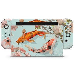 Könnte beinhalten: Eine Nintendo Switch Konsolenhaut mit blauem Hintergrund und einem Design aus zwei Koi-Karpfen, die im Kreis schwimmen. Die Fische sind orange, rot und schwarz mit weißen Akzenten. Das Design beinhaltet auch rosa Blumen und weiße Wolken.