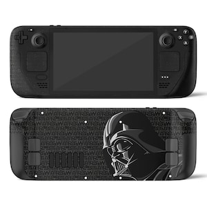 May include: Black handheld gaming console with a Darth Vader design on the back. The console has a screen, buttons, and joysticks. The back features the Star Wars logo in black and grey.