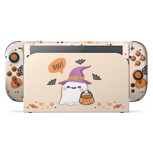 May include: A Halloween-themed Nintendo Switch console. The console features a cartoon ghost wearing a witch hat and holding a pumpkin-shaped treat bag. The Joy-Cons and console body are decorated with pumpkins, bats, and candy corn.