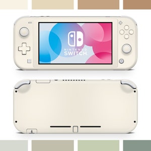 Puede incluir: Una consola de juegos portátil Nintendo Switch Lite blanca con un diseño abstracto colorido en la pantalla. La consola se muestra tanto en posición cerrada como abierta.