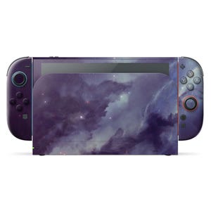 Puede incluir: Una consola Nintendo Switch y mandos con un diseño de nebulosa. El diseño púrpura y azul cubre la consola, la base y los mandos. Los mandos tienen botones y joysticks negros.