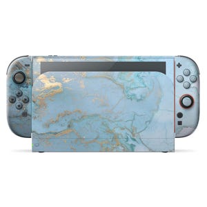 以下が含まれることがあります： 青と金のマーブル模様のNintendo Switchコンソール。Joy-Conコントローラーとドックは同じ大理石模様です。コンソールには黒い画面とさまざまなボタンとコントロールがあります。