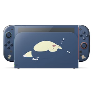 以下が含まれることがあります： ネイビーブルーのNintendo Switchコンソールと、眠っている漫画のキャラクターが描かれたお揃いのドック。 コントローラーには赤と青のアクセントがあり、小さなキャラクターデカールが付いています。 コンソールは白い背景にあります。