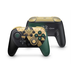 Puede incluir: Un mando de videojuegos inalámbrico con un patrón geométrico negro y dorado en la placa frontal, empuñaduras de color verde oscuro y una sección superior dorada. El mando incluye botones estándar, joysticks y una cruceta con un emblema central.