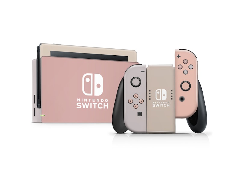 May include: A pink and beige Nintendo Switch console with two Joy-Con controllers. The console has the Nintendo Switch logo and the text "NINTENDO SWITCH". The Joy-Con controllers have the Nintendo Switch logo and the text "NINTENDO SWITCH".