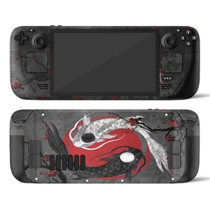 Könnte beinhalten: Eine graue und schwarze Spielekonsole mit einem schwarzen und weißen Fischdesign auf der Rückseite. Die Fische schwimmen in einem Kreis um einen roten Kreis. Die Konsole hat einen Bildschirm auf der Vorderseite und Knöpfe an den Seiten.