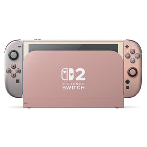 以下が含まれることがあります： ローズゴールドのNintendo Switchコンソールと、お揃いのJoy-Conコントローラー。ドックにはNintendo Switchのロゴとハートのデザインがあります。左側のコントローラーはライトグレーに青のアクセント、右側のコントローラーはローズゴールドです。