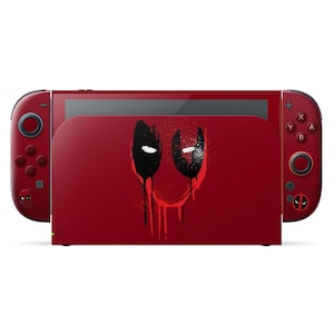 May include: A red Nintendo Switch console with matching Joy-Con controllers. The dock features a black and white graphic of Deadpool's mask. The controllers and dock are red with black buttons and accents. The overall design is a tribute to the Marvel Comics character.