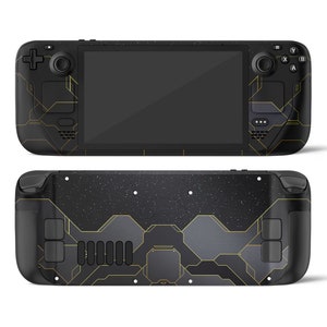 Può includere: Una console per videogiochi portatile nera con un motivo geometrico dorato. La console ha uno schermo, pulsanti e joystick.