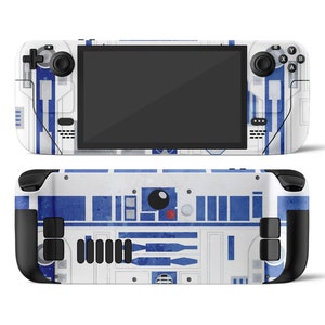 May include: A white and blue video game console featuring an R2-D2 design. The console has a screen, buttons, and joysticks.