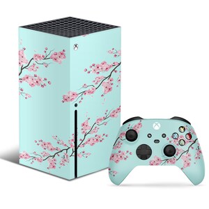 May include: A light blue Xbox Series X console and matching controller with a pink cherry blossom design.