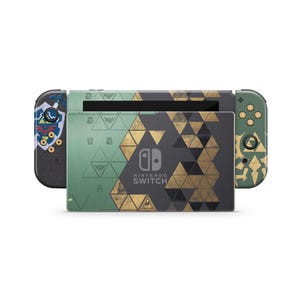 Könnte beinhalten: Eine Nintendo Switch Konsole mit einer grünen und dunkelgrauen Folie mit goldenen geometrischen Dreiecksmustern. Die Dockingstation zeigt das Nintendo Switch Logo, der linke Controller ein blaues Schildelement und der rechte Controller goldene Tasten.