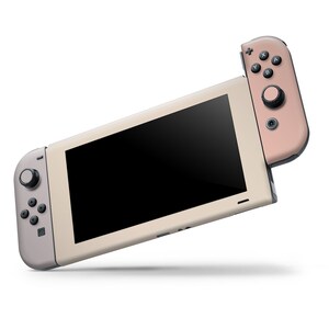 May include: A light beige Nintendo Switch console with a rose gold Joy-Con controller attached. The console has a black screen and a gray button on the left side.