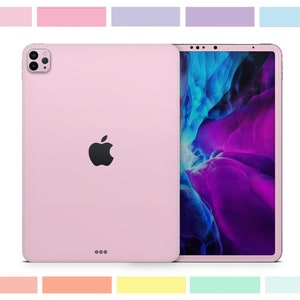 May include: A pink iPad with a black Apple logo on the back. The screen is displaying a colorful abstract design.