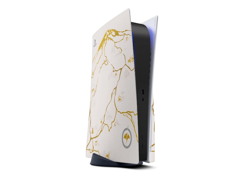 Peut inclure: Une console de jeu blanche et noire avec un motif de carte dor&eacute;. La console a une section centrale noire avec des ports et une lumi&egrave;re bleue. Le design pr&eacute;sente un motif de carte dor&eacute; sur les panneaux lat&eacute;raux blancs.