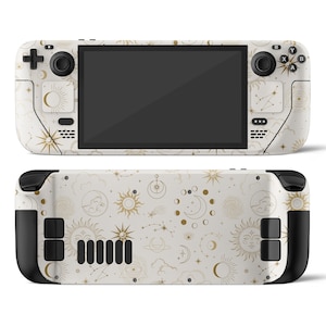 Può includere: Una console per videogiochi portatile bianca con un motivo celeste dorato. La console ha uno schermo nero e pulsanti neri. Il motivo include lune, stelle e soli.