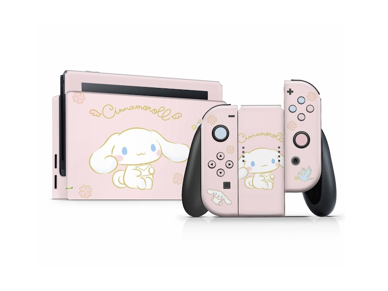 May include: Pink Nintendo Switch console and Joy-Con controllers with a Cinnamoroll design. The console and controllers feature a pink background with a white Cinnamoroll character and floral accents.