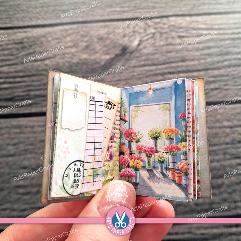 May include: A miniature open book featuring a left page with a blank white tag, a lined ledger sheet, and a circular stamp dated Dec 25 1932. The right page displays a colourful illustration of a flower shop interior with various potted blooms.