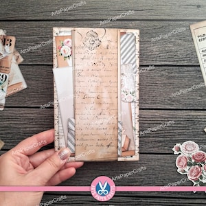 May include: A handmade vintage-style journal with a collage of aged paper, floral accents, and decorative strips. The journal features handwritten script, a floral image, and a chevron pattern. The ArtsPaperCrafts logo is visible.