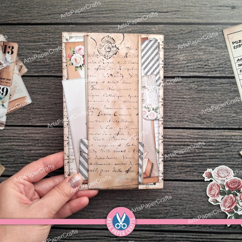 May include: A handmade vintage-style journal with a collage of aged paper, floral accents, and decorative strips. The journal features handwritten script, a floral image, and a chevron pattern. The ArtsPaperCrafts logo is visible.
