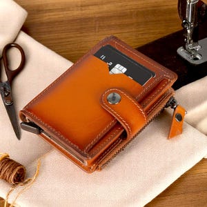 Portefeuille minimaliste en cuir RFID pour homme avec porte-cartes escamotable, poche pour monnaie doublée de daim, fenêtre d'identification et fermeture zippée sécurisée en métal