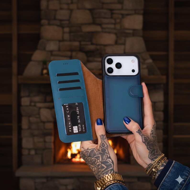 May include: Teal blue leather phone case with a wallet feature. The case is open, revealing card slots and a brown interior. A credit card is visible in one of the slots. The phone case is designed to fit a smartphone.