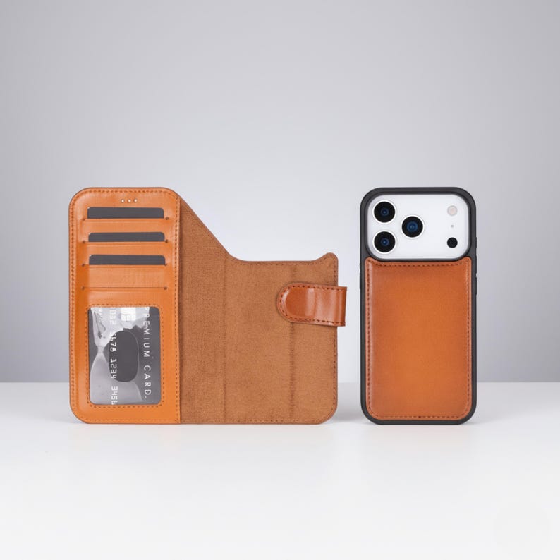 May include: A brown leather phone case with a black frame and a separate wallet case. The wallet case has slots for cards and a clear window. The phone case has a brown leather back. The cases are on a white surface.