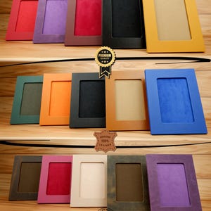 May include: A set of 10 leather picture frames in various colours, including red, purple, brown, black, yellow, green, orange, blue, beige, and purple. The frames are all made of genuine leather and have a hand-crafted quality. The frames are all the same size and have a simple, elegant design.