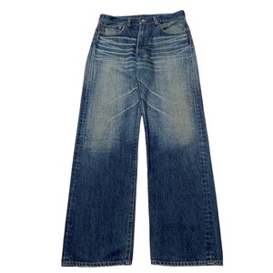 May include: A pair of blue denim jeans with a faded and distressed look. The jeans have a straight leg and a relaxed fit.