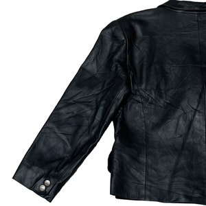 May include: A black leather jacket with a long sleeve and a button on the cuff.