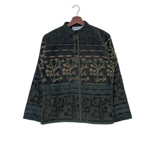 May include: A green, brown, and black patterned jacket with a button closure and a small pocket on each side. The jacket has a label that reads "Flashback".